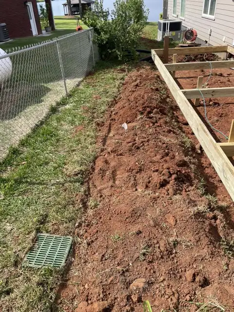 Trench for an underground gutter line along a fence