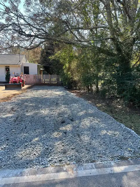 New gravel parking pad beside a fence