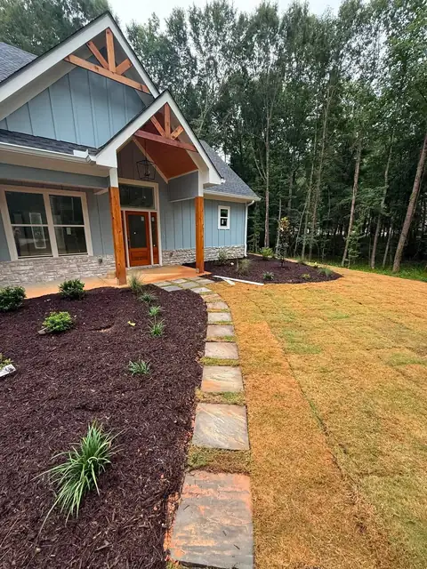 Stepping stones through new sod beside a planting bed