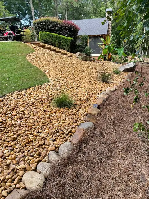 River rock bed and mulch along a lawn