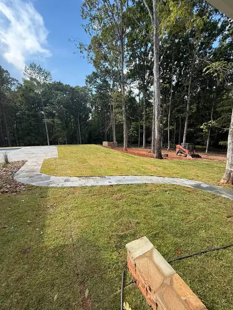 Sod along a wooded lot with a concrete walk