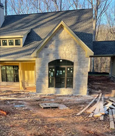 Cut stone veneer and an arched window on a new house