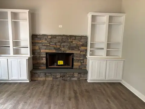 Stacked stone fireplace between built-in cabinets
