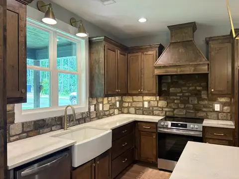 Stone backsplash behind a kitchen range hood