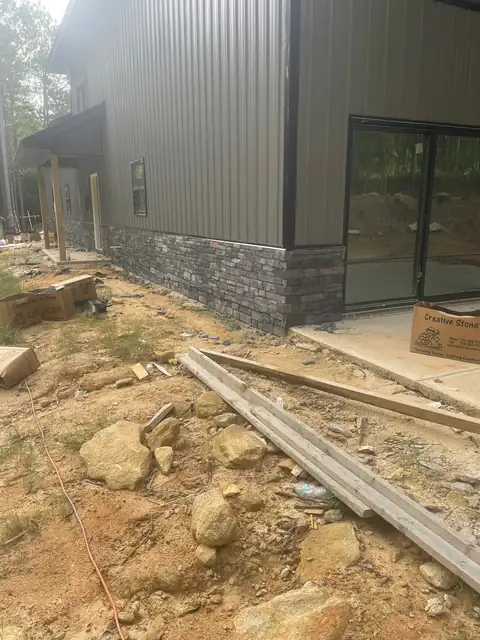 Stone wainscot on a metal-sided house