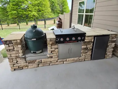 Stone grill island with a ceramic cooker and griddle