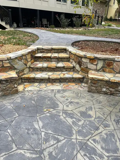 Stone steps and seating wall rising from the patio