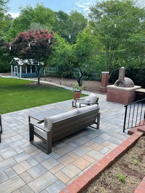Paver patio with an outdoor sofa and brick soldier-course edging